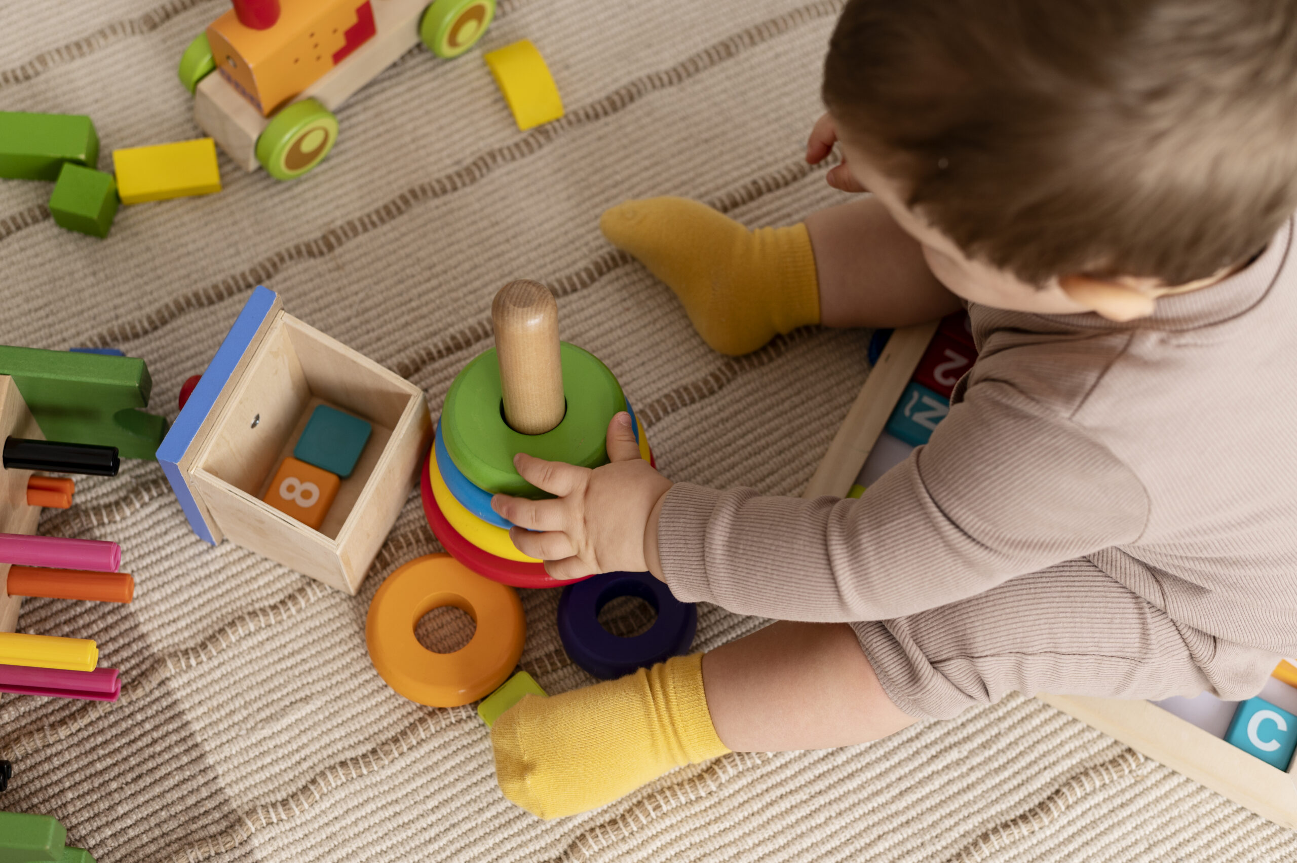 bambino-ad-alto-angolo-che-gioca-con-giocattoli-colorati