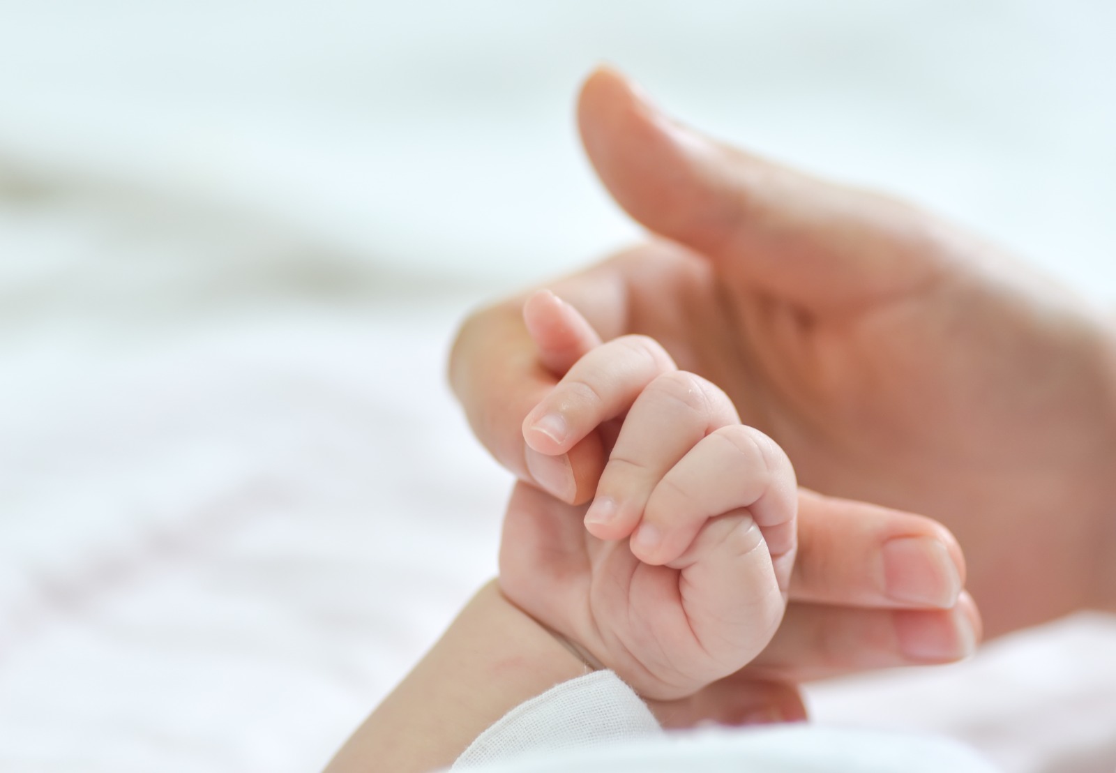 mano di bimbo che tiene il dito della mamma, arrivo del nuovo beb&egrave;